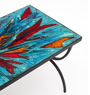 Coffee table from Vallauris on the French Riviera. This piece has a structure of hand-hammered forged iron. It is covered with thick terra-cotta hand painted tiles with an abstract motif in vivid colors. Add some vivid color into your space with a coffee table. 
