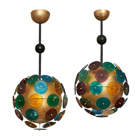 A pair of vintage sputnik chandeliers, from Murano, Italy. Light shines through a perforated galvanized brass sphere. Multicolored Murano glass stemmed discs project from the spheres. These are quite a statement pair. Chandeliers are the perfect way to add color and vibrance into your home and life.