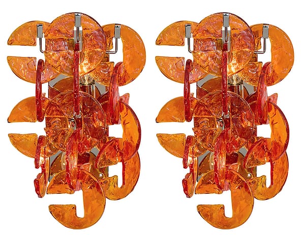 Pair of Murano glass sconces from the island of Murano, Italy. The sconces feature multiple C shaped orange hand-molded glass components in the “ferro Battuto” fashion. They sit on a chromed steel structure. This pair has been newly wired to fit US standards. Include boldness on your walls with sconces.