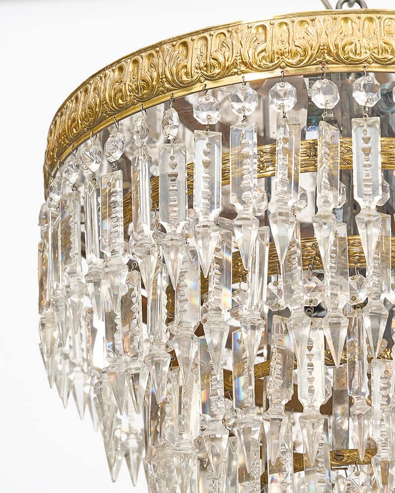 Exquisite pair of antique French Baccarat chandeliers from Paris. Adorned with meticulously cut crystal pendants, delicately suspended from embossed stacked crowns, these captivating fixtures exude timeless elegance. This pair features intricate craftsmanship and attention to detail.