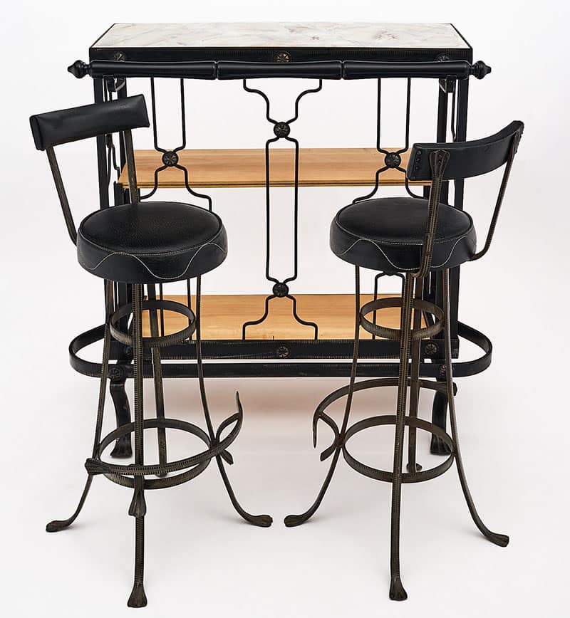 Bar and stools, French, from the Art Deco period. This set is made of hand-hammered forged iron with a custom glass top. The original vinyl upholstery is on the stools and there are two interior wood shelves. The dimensions listed are for the bar, the dimensions for the stools are below. 
