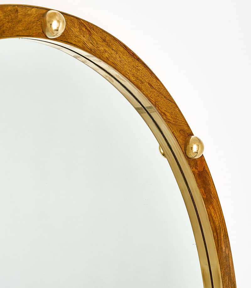 Italian wooden and brass mirror. This round mirror features a wooden frame finished in French polish with half spheric solid brass studs.